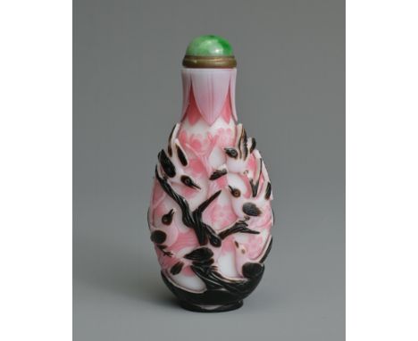 A CHINESE BLACK OVERLAY PINK AND WHITE SNUFF BOTTLE, QING DYNASTY. Of flattened ovoid form, well carved in relief featuring t