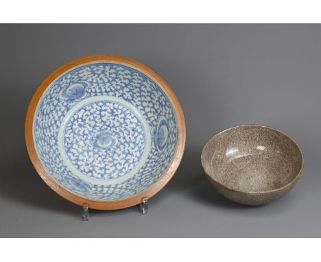 TWO CHINESE PORCELAIN BOWLS, 19TH CENTURY. To include a Batavian ware basin, decorated with scrolling floral motifs in underg