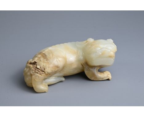 A CHINESE PALE CELADON AND RUSSET JADE CARVING OF A LION, MING DYNASTY. The figure recumbent with its tail tucked under its b