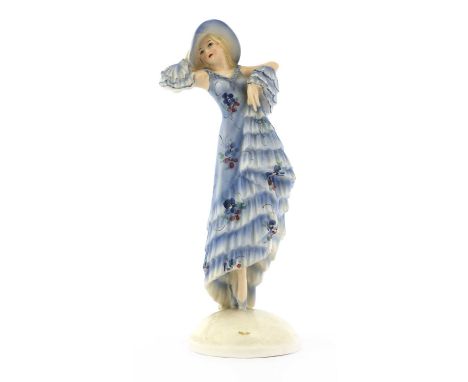 A Goldscheider figure of a lady in a blue dress and hat, designed by Josef Lorenzl (1892-1950), raised on an oval plinth, sig