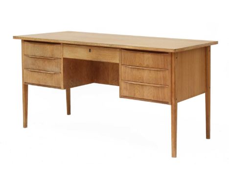 A Danish light oak desk,with three drawers each side of a single frieze drawer, a shelf to the reverse, 138cm wide69cm deep73