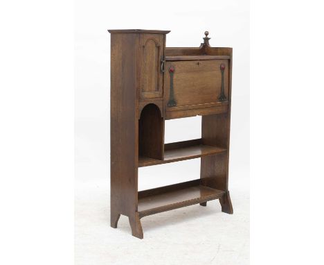 An Arts and Crafts oak student's bureau,the folding front with brass fittings, each with a red enamelled cabochon, opening to