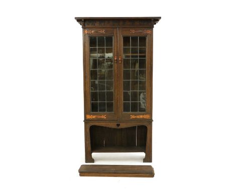 An Arts and Crafts oak bookcase,the top with applied ebonised lettering 'Judge not a book by the cover', above a pair of bar-