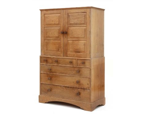 A Cotswold School walnut linen press, c.1952, by Keith Cooper, Old Chapel, Lytchett Matravers, Dorset, with a moulded edge, c