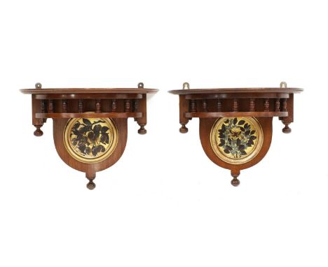 A pair of Aesthetic wall brackets, each with a spindle gallery and finials, centred with a painted panel of flowers, 39cm wid