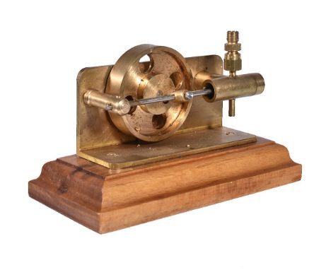 A small brass steam engine, with single cylinder and disc flywheel. Mounted on wooden plinth Length 16cm x 8cm. Overall heigh