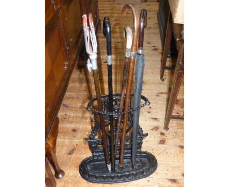 Cast metal stick stand, three walking sticks, brolly and shooting stick