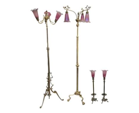 Two early 20th century Art Nouveau brass three branch standard lamps, both with coloured shades, one with shades pointing up,