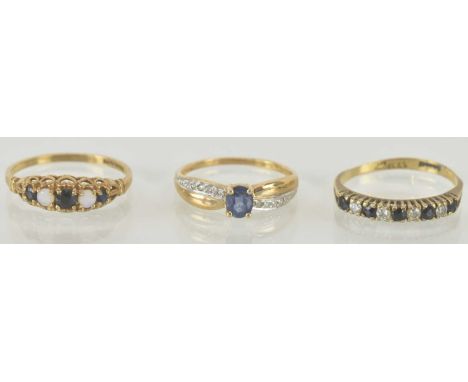Three 9ct gold dress rings comprising a sapphire and cubic zirconia half hoop ring, size K, a 9ct gold sapphire and opal ring