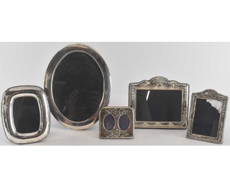 An Elizabeth II hallmarked silver oval photograph, Sheffield 1983, 22.5 x 17.5cm, and four further hallmarked silver photogra