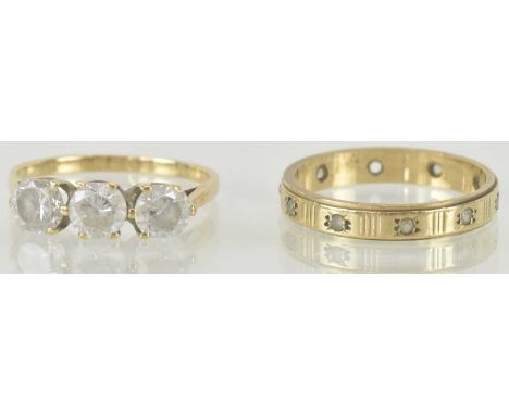 Two 9ct gold dress rings, one with three close set white stones, size M, and a band ring with engine turned decoration, size 