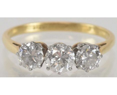 An 18ct gold three stone diamond set ring, the central stone approx 0.5ct, flanked by two further claw set stones, each appro