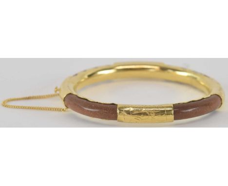 A yellow metal mounted hardstone snap bangle, diameter approx 7.5cm.