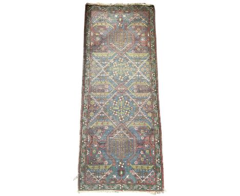 An early 20th century Turkish blue ground runner, with geometric designs and green ground florally decorated border, 154 x 62