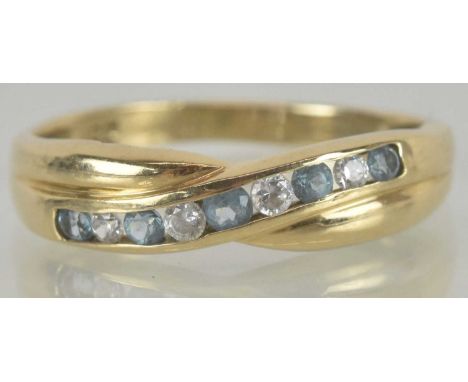 A 9ct gold dress ring, with crossover top, set with white and blue stones, size O, approx 1.9g.