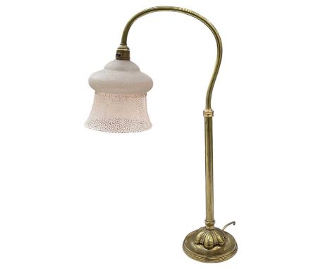 An early 20th century brass desktop reading lamp, with textured coloured glass shade, height 55cm.