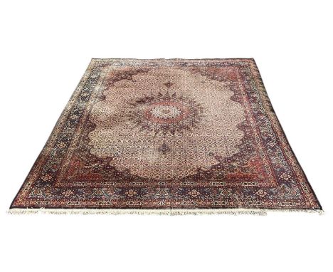 A large modern Persian style red ground rug, with florally decorated blue border, 380 x 295cm.