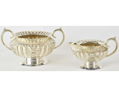 A late Victorian white metal twin handled sugar bowl, width 19cm, and matching milk jug, combined approx 24ozt/747.5g (2).