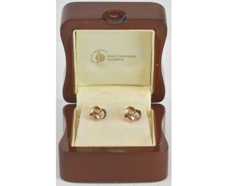 JANET ISHERWOOD; a pair of open ribbon knot stud earrings, combined approx 0.6g, in a wooden presentation box.Condition Repor