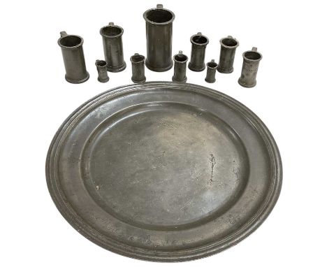 An 18th century circular pewter tray, diameter approx 49cm, with a set of ten graduated pewter measures/mugs, largest height 