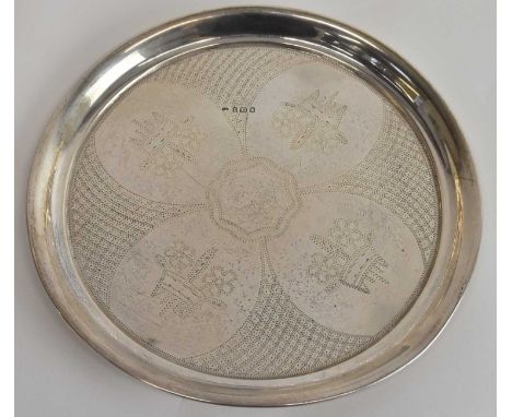 J SEVING; a George V hallmarked silver circular dish with four panels with embossed decoration of flowers in basket, London 1