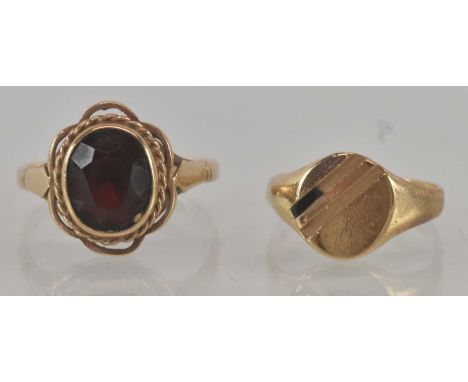 A 9ct yellow gold onyx set signet ring, size I/J, and a 9ct yellow gold garnet set ring, the central garnet approx 2ct, size 