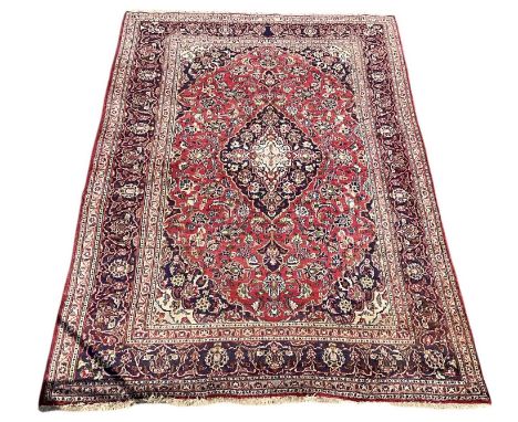 A modern red ground Persian style floral decorated carpet, with cream/blue border with foliate decoration, 300 x 200cm.