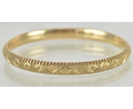 A 9ct gold bracelet with pull out clasp and diamond cut repeating pattern, internal diameter 5.8cm, weight 8g.