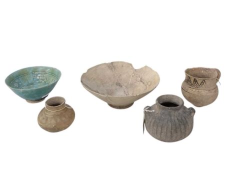 Five pieces of 12th century and later Persian ceramics, including a blue glazed shallow footed bowl, diameter 15cm, a larger 