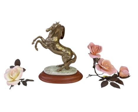 CAPODIMONTE, CORTESE; a porcelain figure of a rearing horse in a gold finish, on a round plinth raised on stepped wooden plin