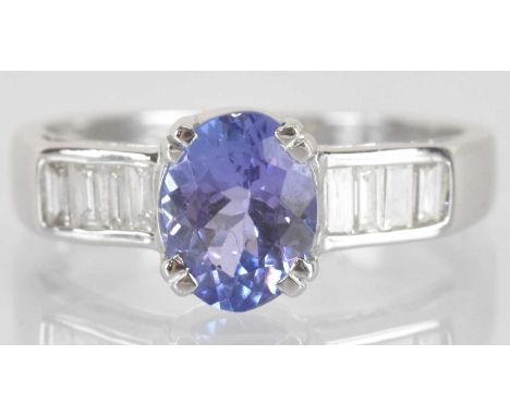 An 18ct white gold tanzanite and diamond ring, the central oval cut tanzanite approx 1.5ct, flanked by shoulders each set wit