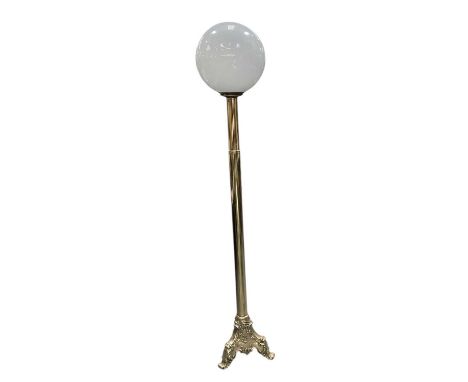 An early 20th century brass standard lamp, with white opaque glass Art Deco spherical shade, height 163cm.