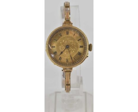 An 18k lady's wristwatch with allover floral decoration, the turned gold dial set with Roman numerals and outer minute track,