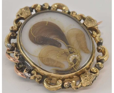 A late 19th century yellow metal mounted mourning brooch, with intertwined lock of hair, approx 25.3g.