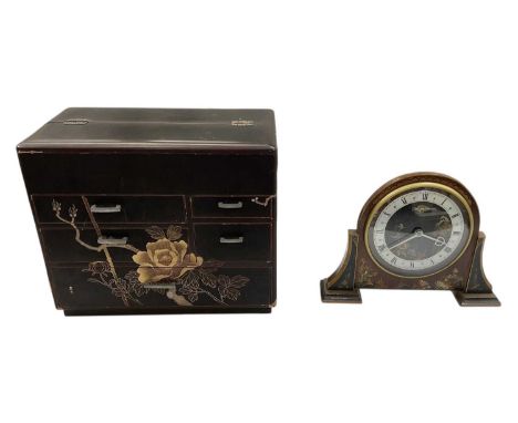 A modern Japanese black lacquered tabletop jewellery box, with hinged lid enclosing fitted pull-out interior, above an arrang