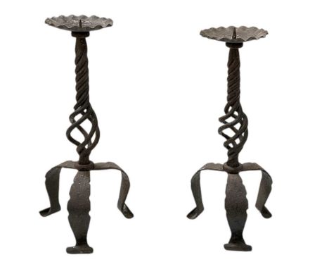 A pair of early 20th century cast iron tripod pricket candlesticks, with barley twist support columns, both height 32cm.