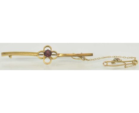 An amethyst claw set gold bar brooch with steel pin, length 4.5cm.
