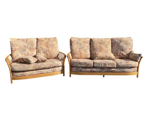 ERCOL; a modern light elm spindle back three seater sofa, width 194cm, and a matching two seater spindle back light elm sofa,