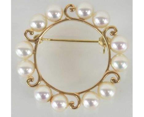 A circular open brooch marked '14k', with six groups of two small cultured pearls, diameter 3cm, approx 6g.