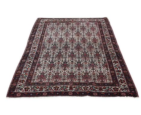 A modern Persian style hand woven floral decorated red ground rug, with cream/blue border, 200 x 150cm.