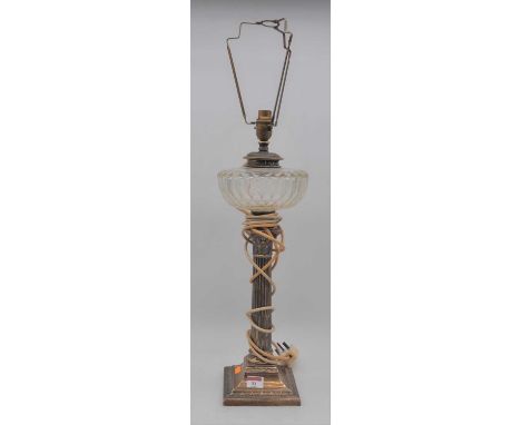 An Edwardian silver oil lamp having a cut clear glass font above a corinthian capital and fluted column, concave square base,