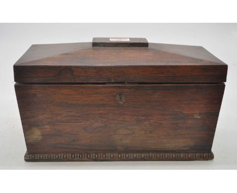 A Regency rosewood tea caddy, of sarcophagus form, the lid lifting to reveal a later glass mixing bowl flanked by twin compar