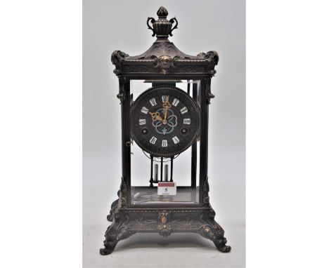A reproduction bronzed metal cased four glass mantel clock, the dial showing Roman numeral enamel cartouches, surrounding clo