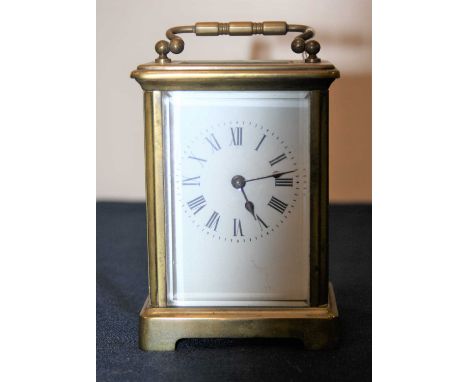 A 20th century lacquered brass cased carriage clock, having an enamelled dial with Roman numerals, visible platform lever esc