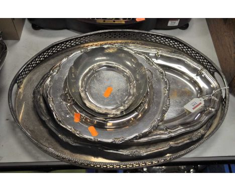 An early 20th century silver plated twin handled gallery tray of oval form together with various silver plated meat platters,