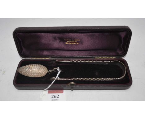 An early 20th century white metal tea caddy spoon having a leaf shaped bowl with entwined tendril handle, together with a pai