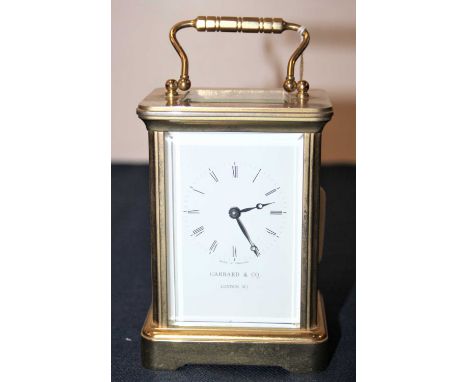 A 20th century lacquered brass cased carriage clock, having enamelled dial with Roman numerals signed Garrard &amp; Co London
