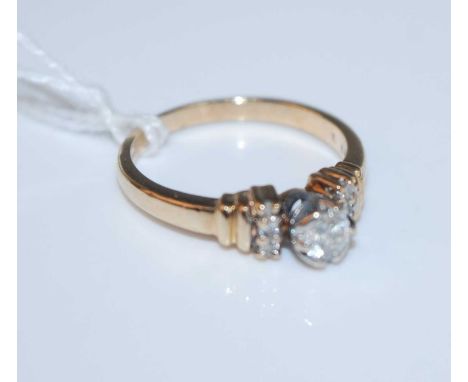 A contemporary 9ct gold diamond ring, having a centre claw set brilliant flanked to either side with three diamond highlights