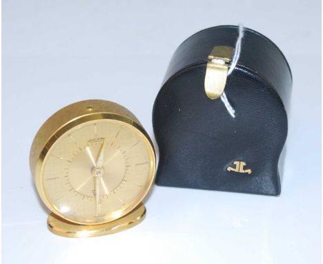 A Jaeger gilt brass cased travelling alarm clock on oval plinth, height 4.9cm, and with original leather travel caseDoes not 