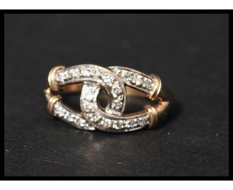 A hallmarked 9ct gold and diamond ring featuring linked lucky horseshoes set with diamonds. Size R. Weight 3g. Maker GJL.